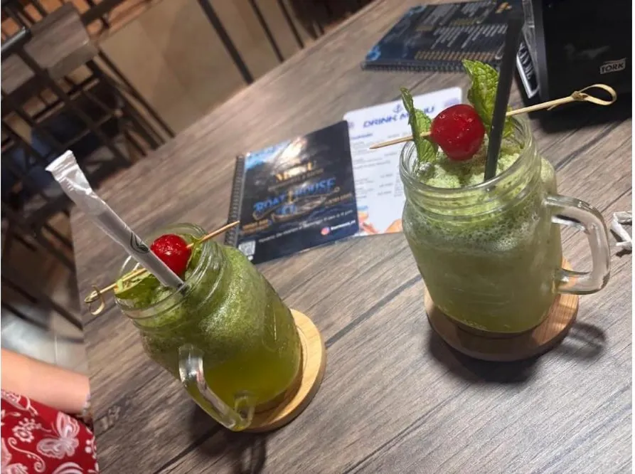 Dos cocteles servidos en la mesa con el menú de Boat House